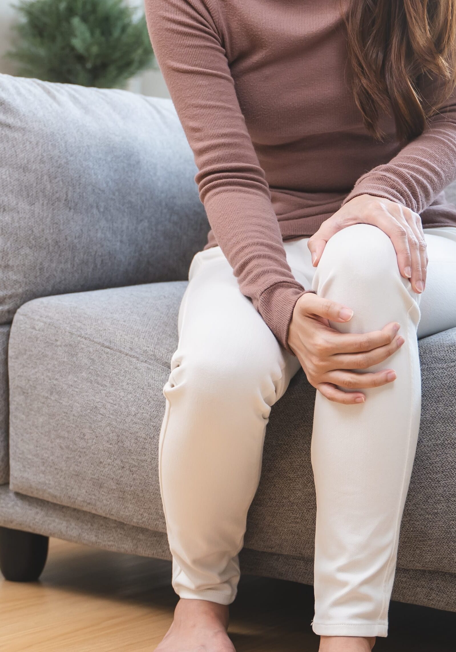 Young Asian woman touching her knee feel pain when move.