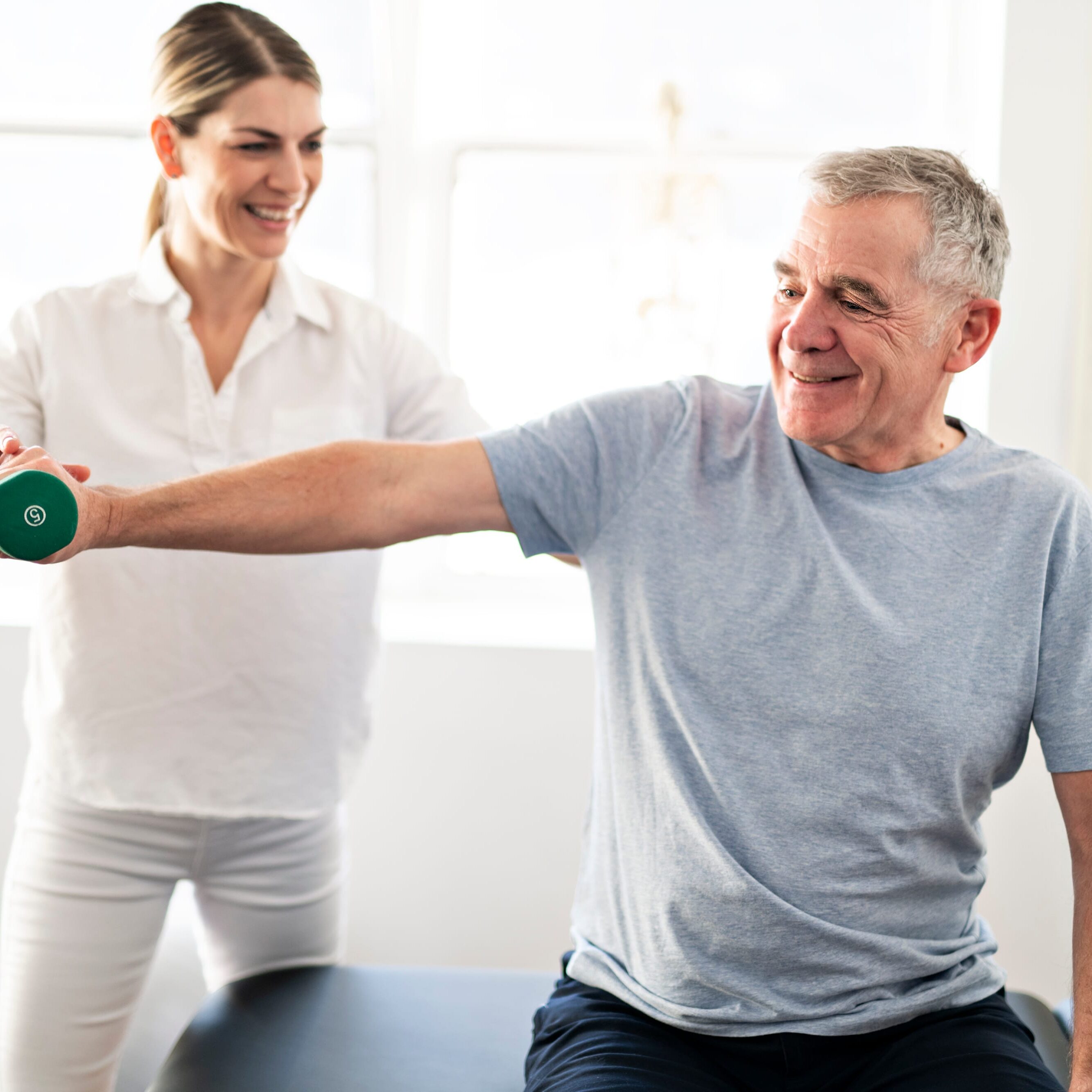 Modern rehabilitation physiotherapy worker with senior client