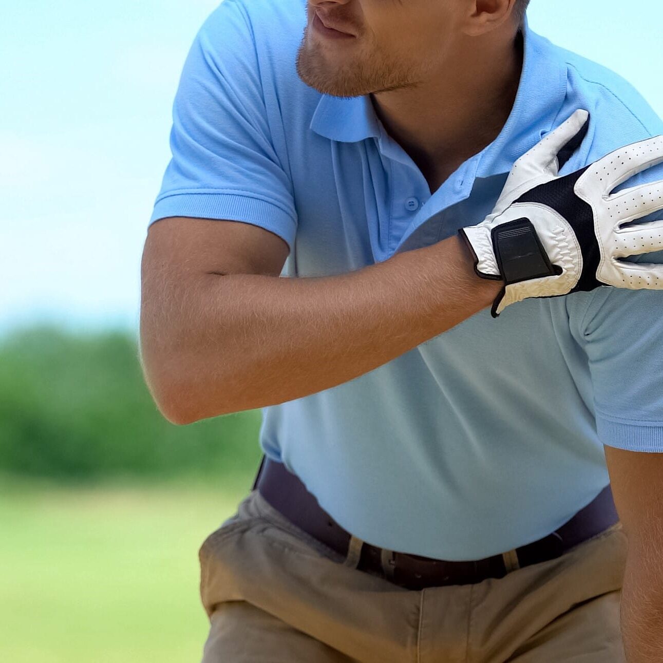 Young male golf player suffering terrible shoulder spasm after shot, trauma
