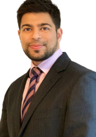 An image of Syed Ahmed, wearing a grey suit, pink shirt and a tie with a vertical pink and purple stripe. He is smiling.