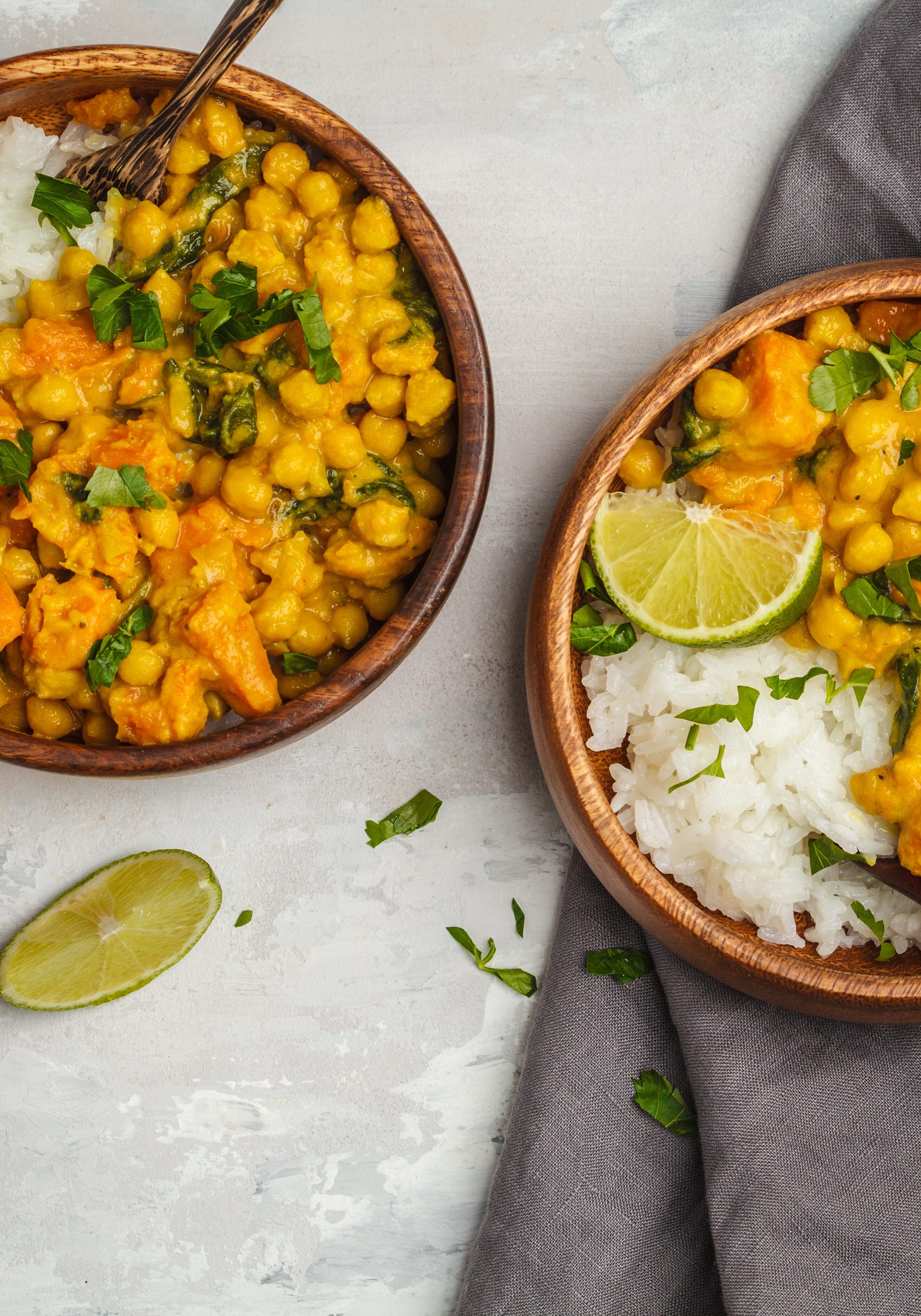 Vegan Sweet Potato Chickpea curry in wooden bowl on a light background, top view, copy space. Healthy vegetarian food concept.